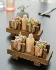 small sushi dishes on wooden trays with candles