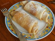 two pastries on a plate with a fork and knife