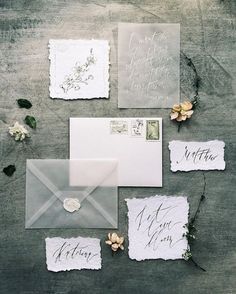 the wedding stationery is displayed on an instagramture with flowers and envelopes