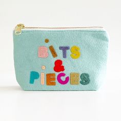 a small blue pouch with the words bits and pieces on it's front side