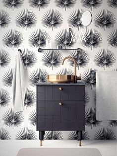 a bathroom with black and white wallpaper, gold faucet sink and mirror