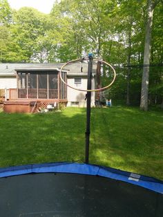 a backyard with a trampoline and a basketball hoop in the middle of it