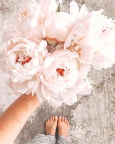 a person holding a bouquet of flowers in their hand with the bottom view of them