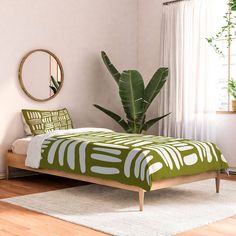 a green and white bed sitting on top of a wooden floor