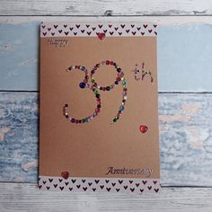 an 80th birthday card with hearts and beads on the front that reads happy 90th anniversary