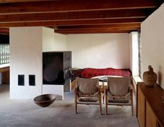 two chairs and a table in a room with wood beams on the ceiling above them