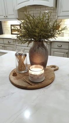 a candle sits on top of a cutting board in the middle of a kitchen counter