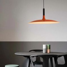 a table with two stools and a light hanging over it