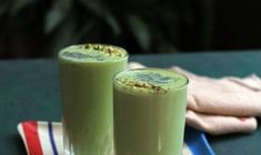 two green drinks sitting on top of a table