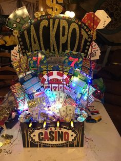 a casino themed birthday centerpiece with candles and cards on it's sides, sitting on a table