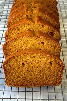 a loaf of pumpkin bread sitting on top of a cooling rack with slices cut off