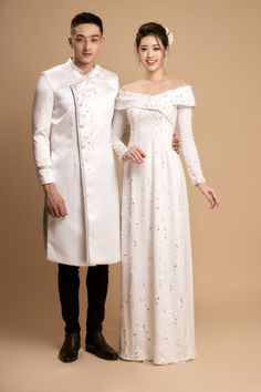 a man and woman in formal wear posing for the camera, both dressed in white