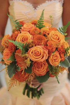 a bride holding a bouquet of orange flowers