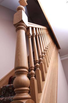 an image of a wooden staircase with handrails and carpet on the ground floor