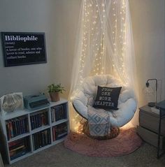 a white chair sitting under a canopy in a room with bookshelves and lights