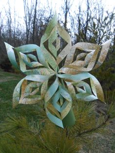 a paper snowflake sitting on top of a grass covered field