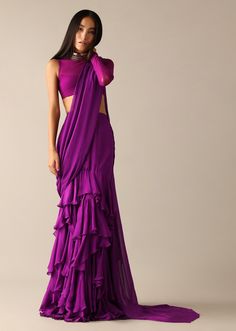 📌Hey! Please message us if you have any questions. We'll definitely assist you. It sounds like you're describing a specific type of Indian ethnic outfit, combining traditional and modern elements. Let me break down the elements you mentioned: 1. Designer Indo Western Georgette Purple Blouse:- =>Designer Blouse:- This implies that the blouse is not a standard, simple design. It likely incorporates unique patterns, embellishments, or cuts created by a designer. => Indo-Western Style:- Indo-Western refers to a fusion of Indian and Western styles. In the context of a blouse, this could mean a blend of traditional Indian blouse elements with modern or Western-inspired design features. =>Georgette Fabric: Georgette is a lightweight, sheer fabric often used in Indian ethnic wear. It has a slight Purple Saree, Net Blouses, Ruffle Saree, Drape Saree, Ready To Wear Saree, Indian Wedding Wear, Georgette Blouse, Ethnic Outfits, Purple Blouse