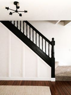 an empty room with a stair case next to a bed and rug on the floor