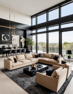 a modern living room with black and beige furniture in front of large windows that look out onto the ocean