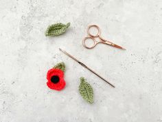 crocheted flowers and leaves are on the table next to knitting needles, scissors and yarn