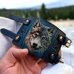 "Hand tooled leather wristband with Wolf design.  This stylish  wristband features a unique design, with a hand-crafted wolf on the front.  Crafted from high-quality leather, this wristband is both durable and stylish.  The wolf muzzle is hand-carved and hand-painted onto the leather, ensuring that each  wristband is unique and one-of-a-kind. CUSTOM orders are always available. Simply send me a message regarding whatever personalization or change you would like to add to your order, and I will r Blue Leather Bracelet As Gift, Blue Leather Bracelet For Gifts, Leather Bracelets With Wrist Strap As Fashion Accessory, Handmade Custom Leather Bracelet, Handmade Leather Cuff Wristband, Blue Leather Bracelet As A Gift, Unique Leather Cuff Bracelet With Strap, Handmade Luxury Leather Bracelet, Handmade Luxury Leather Bracelet Adjustable