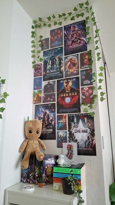 a stuffed animal sitting on top of a table next to a wall covered in movie posters