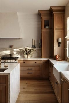 a kitchen filled with lots of wooden cabinets and counter top space next to a sink