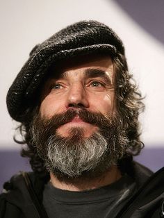 a man with a beard wearing a black jacket and a beanie on his head