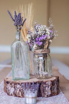 two vases filled with flowers sitting on top of a wooden table next to each other