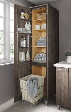 an open cabinet in the corner of a bathroom with towels and other items on shelves