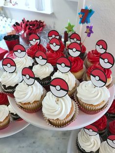 cupcakes with red and white frosting are on plates next to each other