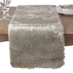 the table is set with silverware and plates on it, along with a fur runner