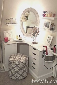 a white vanity with a mirror, stool and other items on the counter in front of it