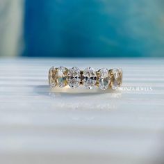 a three stone diamond ring sitting on top of a table