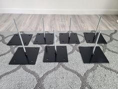 four metal poles are placed in the middle of a carpeted area with a rug