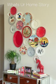 a wall with many plates on it and a potted plant