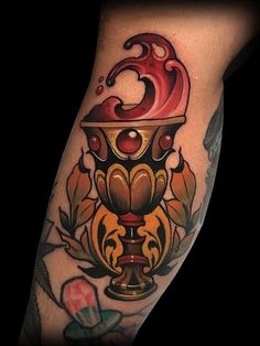 a tattoo on the leg of a man with a red and yellow candle in it