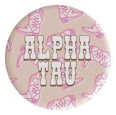 a pink and white button with the words alpha tau on it