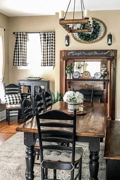 a dining room table with chairs and a mirror on the wall above it is decorated with black and white checkered curtains