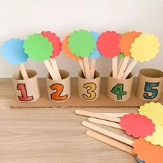 a group of wooden sticks sitting on top of a table next to cup holders with numbers