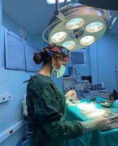 a woman is in the operating room with surgical equipment on her head and lights hanging from the ceiling