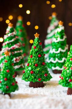 small christmas trees made out of frosting and sprinkles on a table