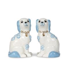 two white and blue dog figurines sitting side by side on a white background