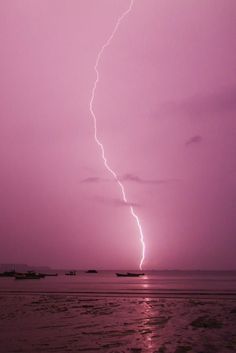 a lightning bolt is seen over the ocean