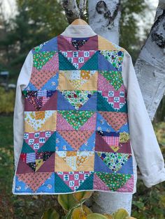 a colorful patchwork jacket hanging on a tree