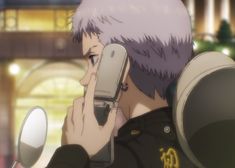 an anime character holding a cell phone to his ear