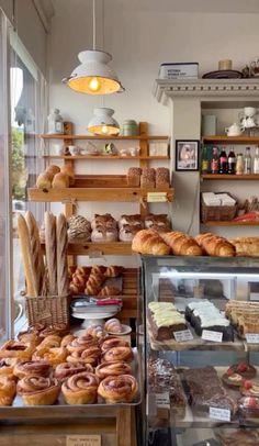 a bakery filled with lots of different types of breads and pastries on display