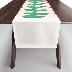 a long table with a white cloth on it and green, purple, and red designs