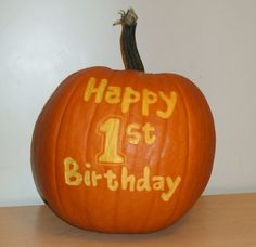 a pumpkin with the number one carved on it's face and writing happy 1st birthday