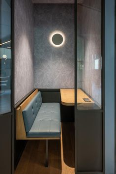 a room with a bench, table and lights on the wall in it's corner